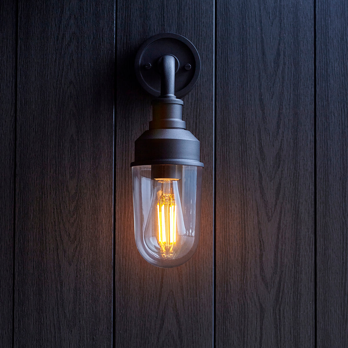 Zwarte wandlamp voor de slaapkamer met transparante kap