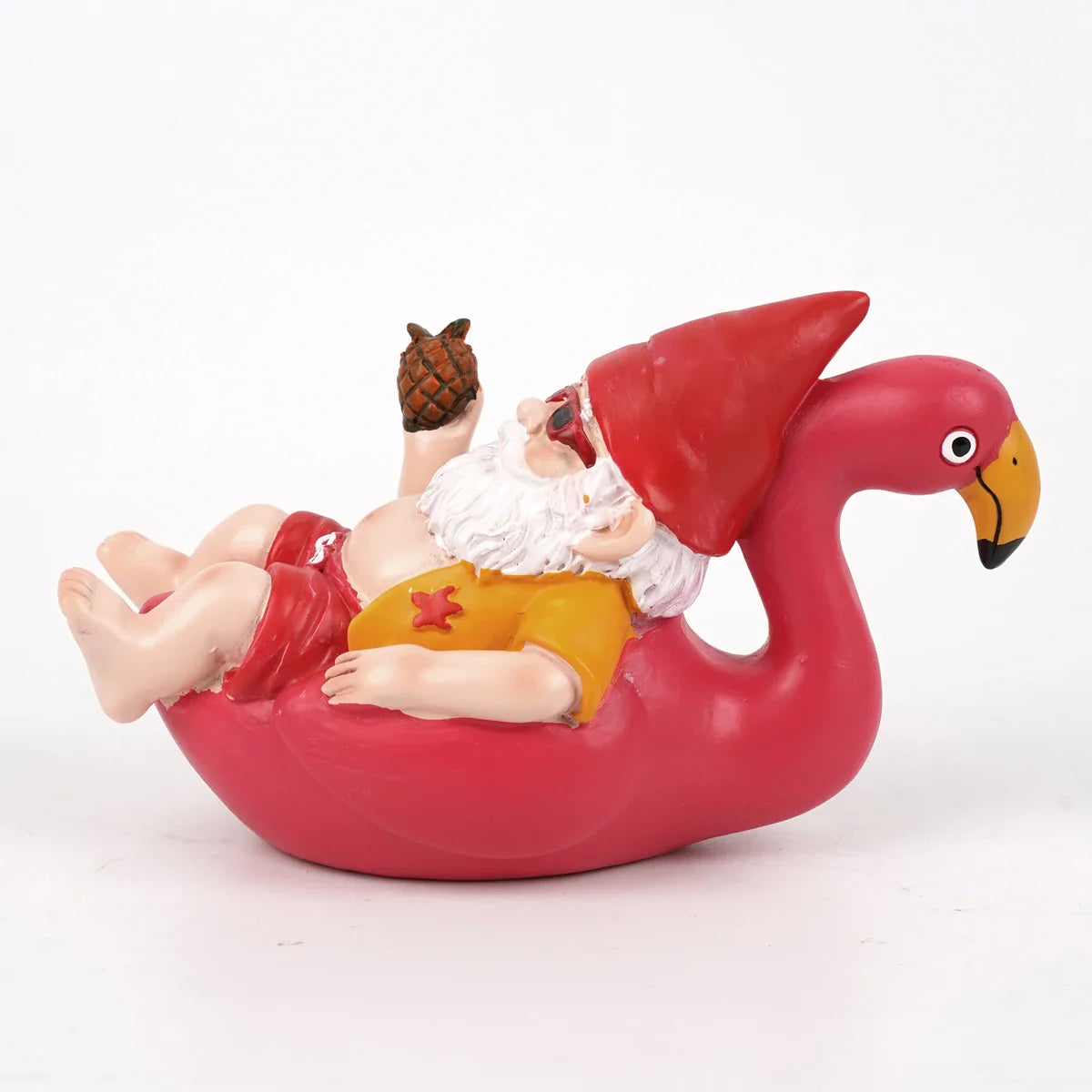 Zabawna figurka krasnala ogrodowego na flamingu z ananasem