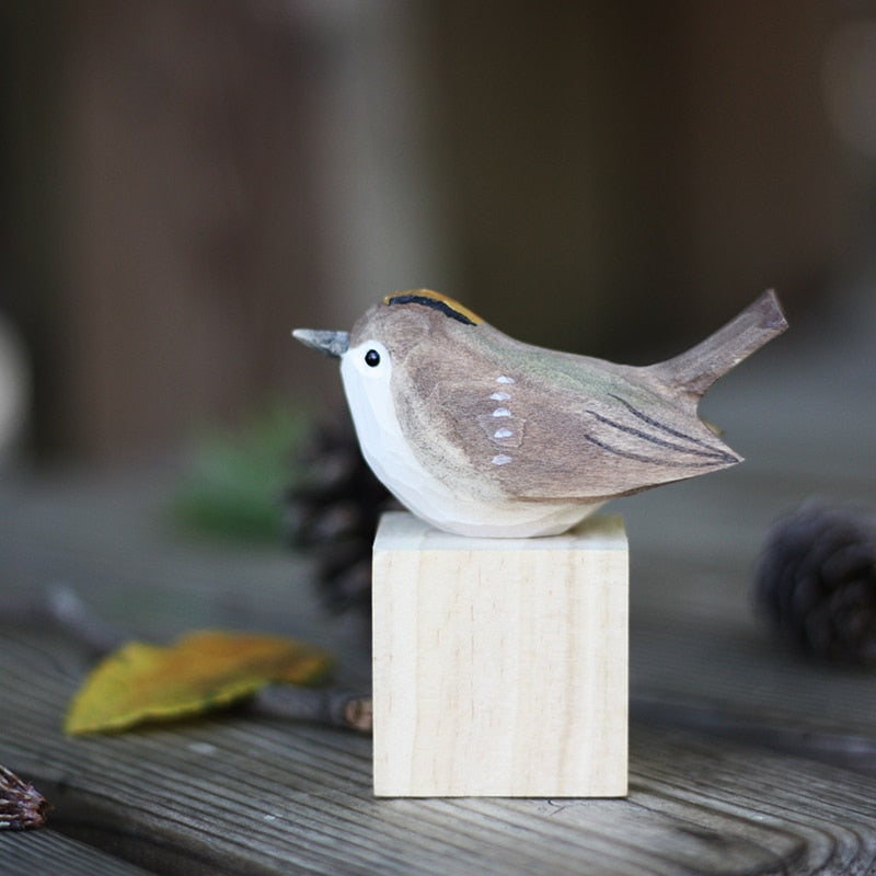 Handbeschilderd houten vogelbeeldje op een voetstuk
