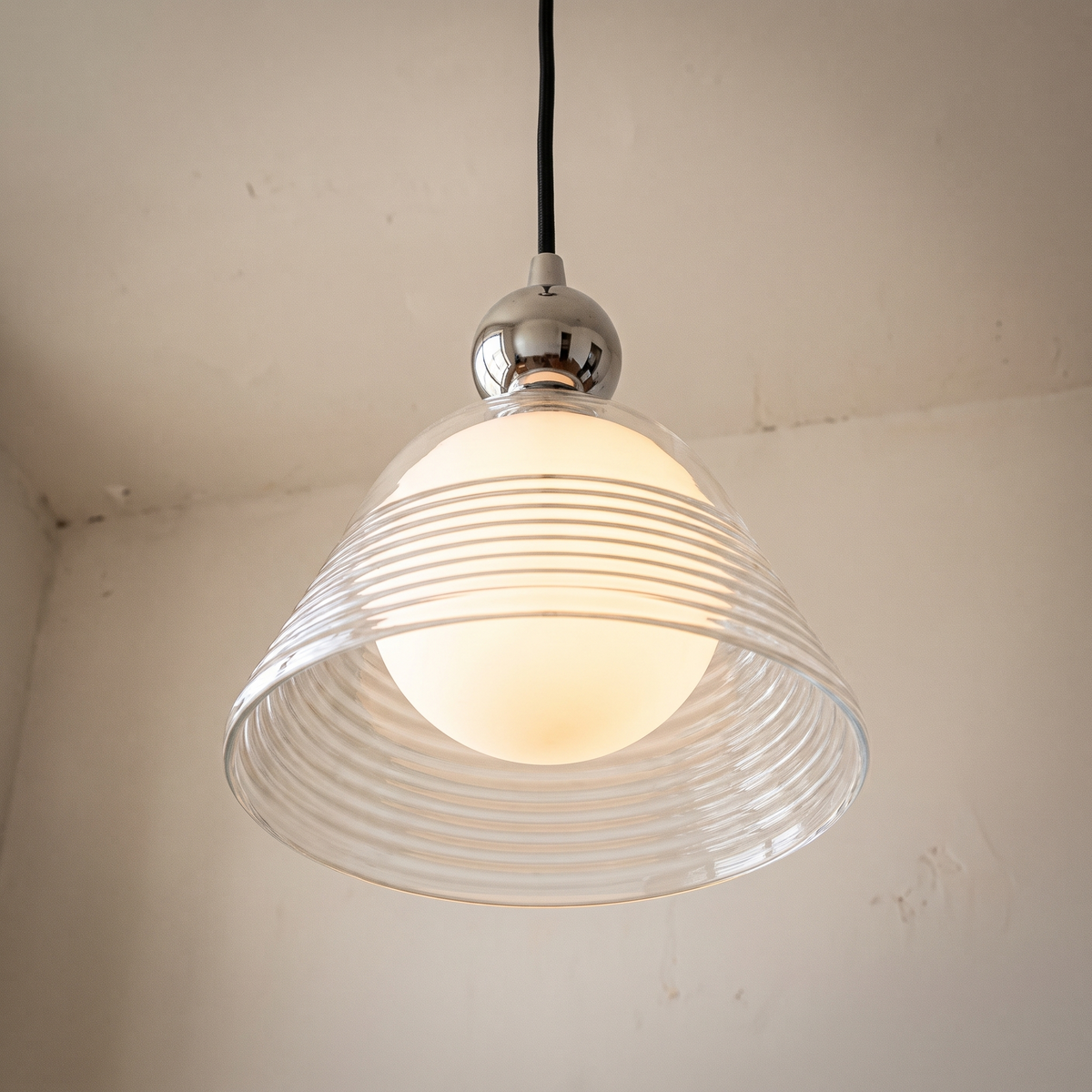 Nowoczesna lampa wisząca z przezroczystym stożkowym kloszem i szklaną kulą