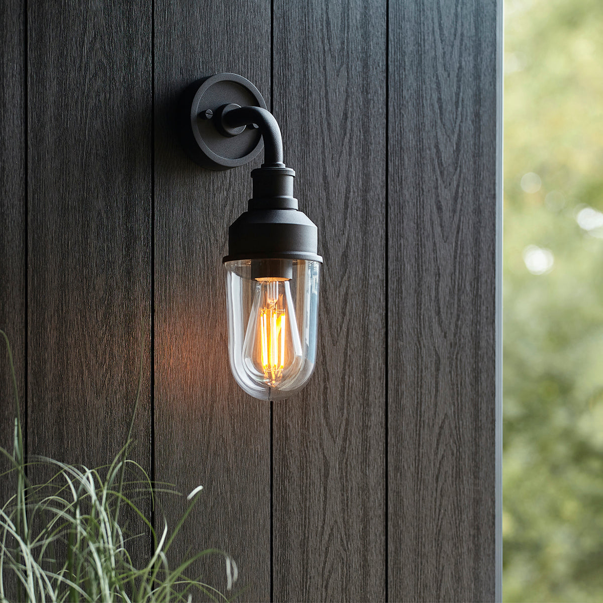Zwarte wandlamp voor de slaapkamer met transparante kap