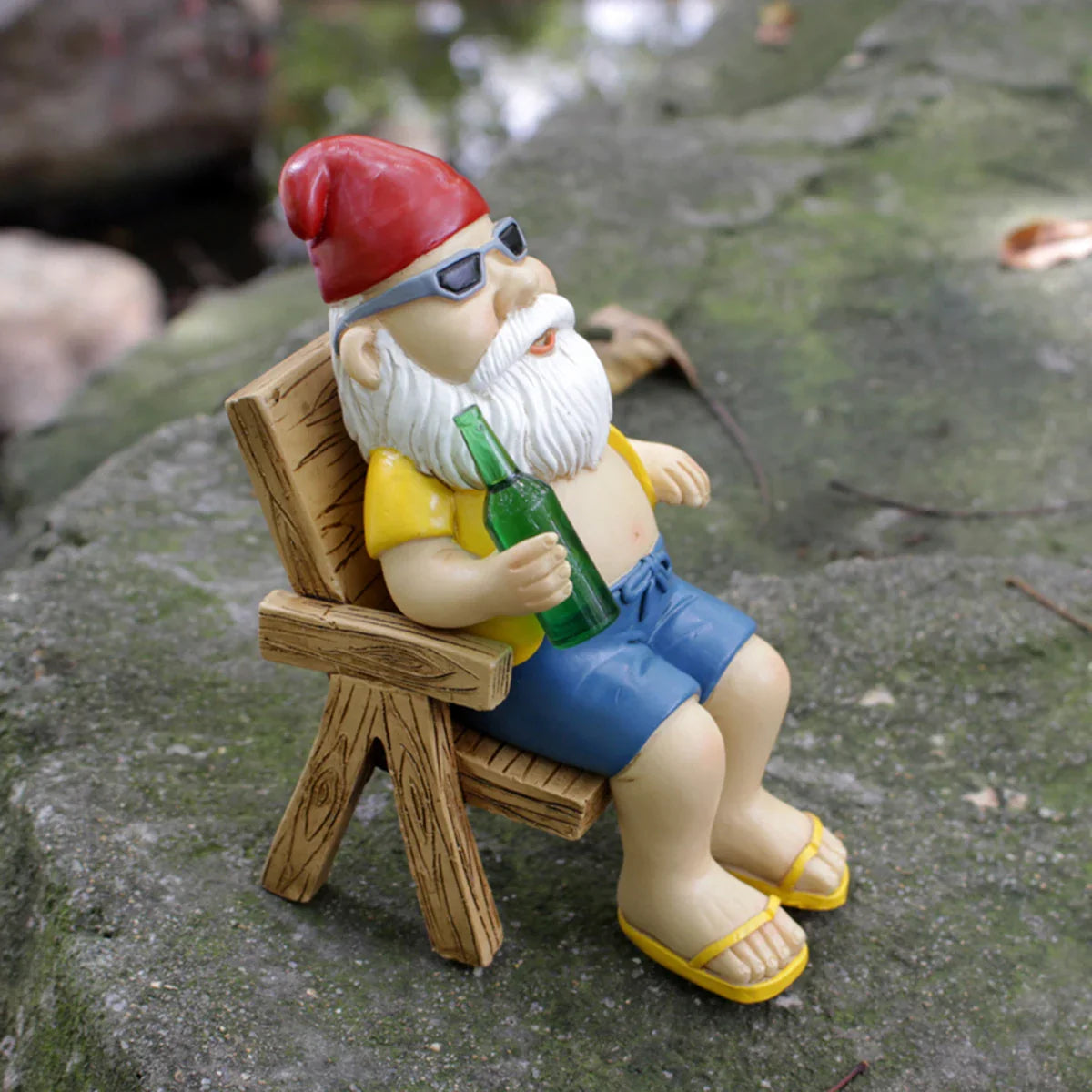 Ozdobna figurka ogrodowa krasnal siedzący na ławce z butelką