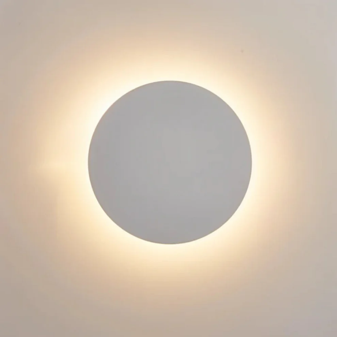 Minimalistyczny kinkiet ścienny z płaską tarczą i świetlną poświatą