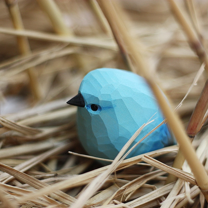 Handbeschilderd houten vogelbeeldje op een voetstuk