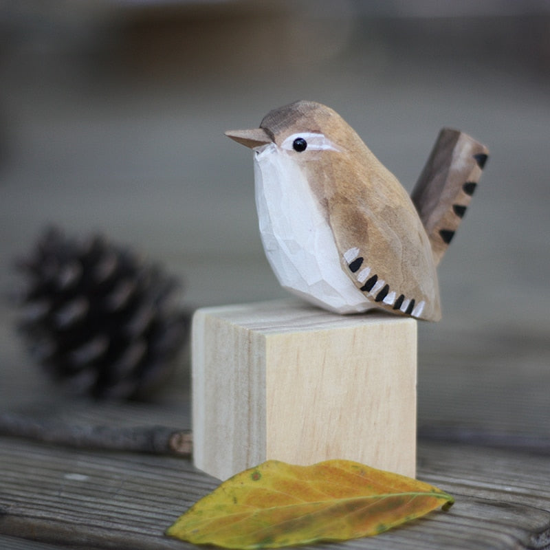Handbeschilderd houten vogelbeeldje op een voetstuk