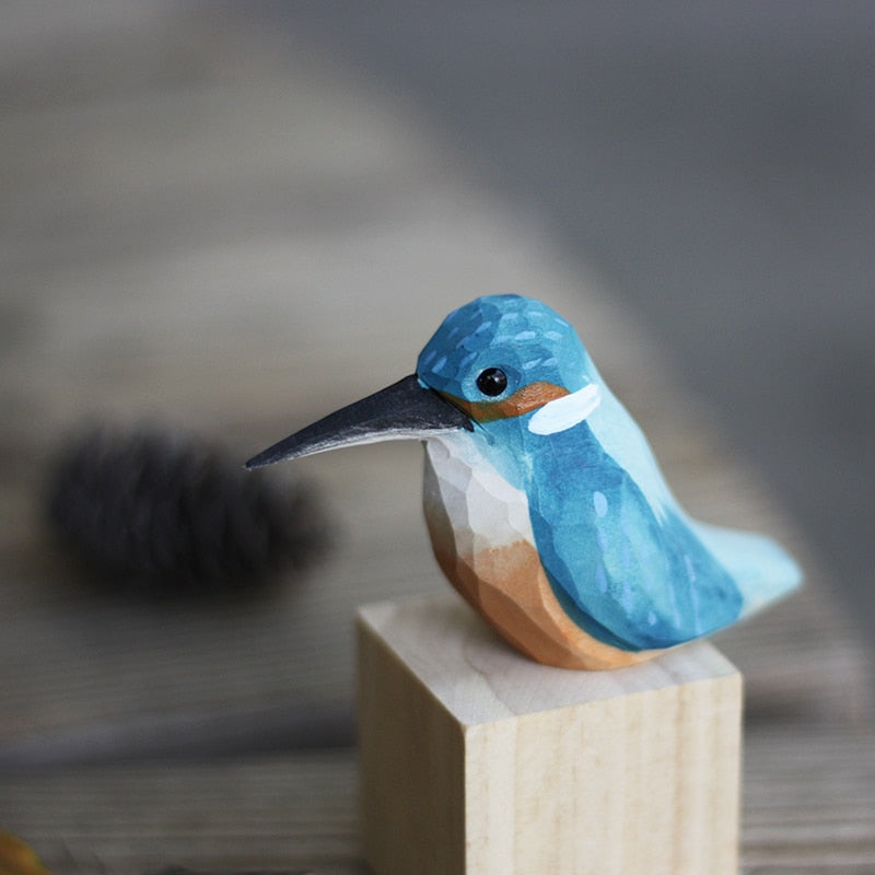 Handbeschilderd houten vogelbeeldje op een voetstuk