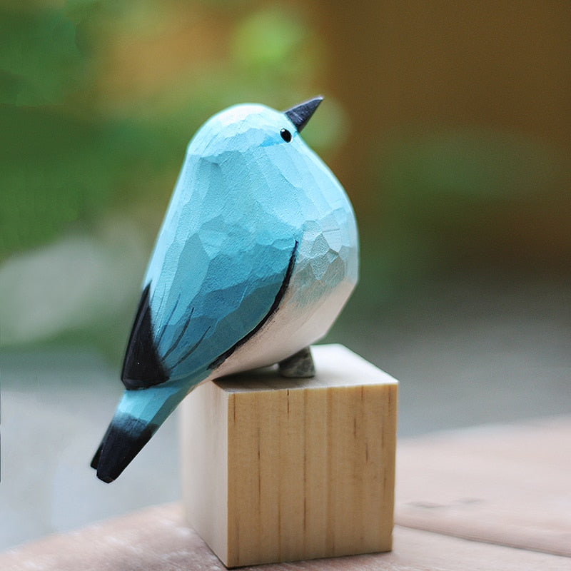 Handbeschilderd houten vogelbeeldje op een voetstuk