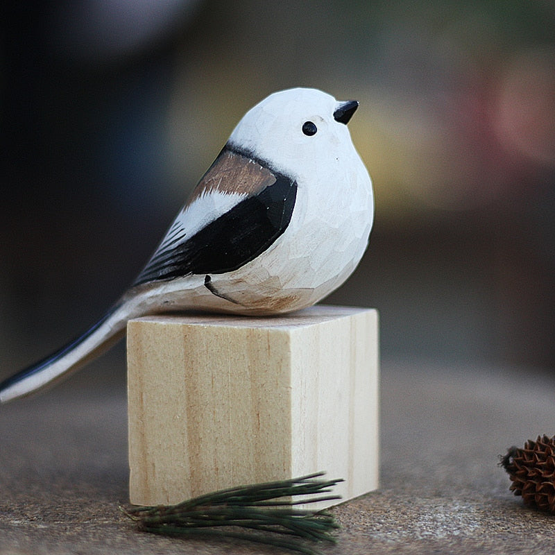 Handbeschilderd houten vogelbeeldje op een voetstuk