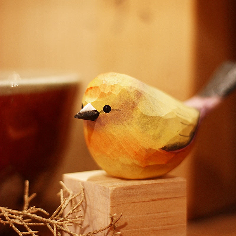 Handbeschilderd houten vogelbeeldje op een voetstuk