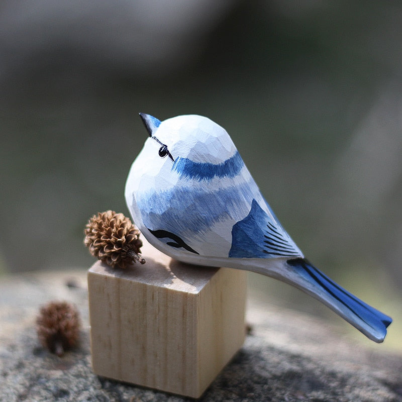 Handbeschilderd houten vogelbeeldje op een voetstuk